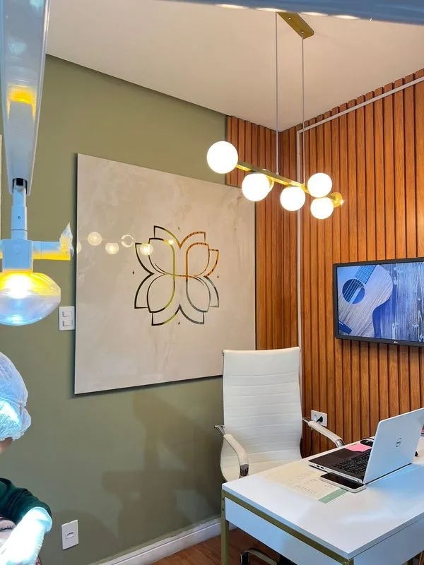 Sala de atendimento com o símbolo da Humanized na parede e luminárias pendentes