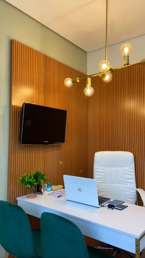 Sala de consulta com parede ripada de madeira, poltrona e escrivaninha