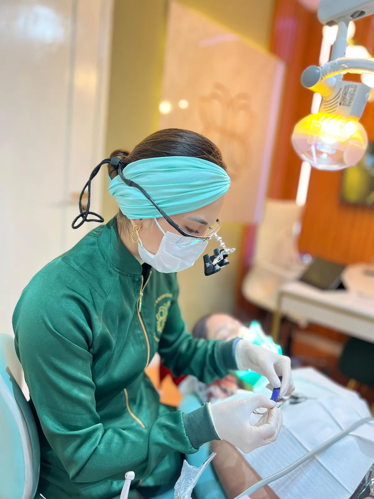 Dentista da Humanized com lupas de aumento, preparando o instrumental ao lado da cadeira