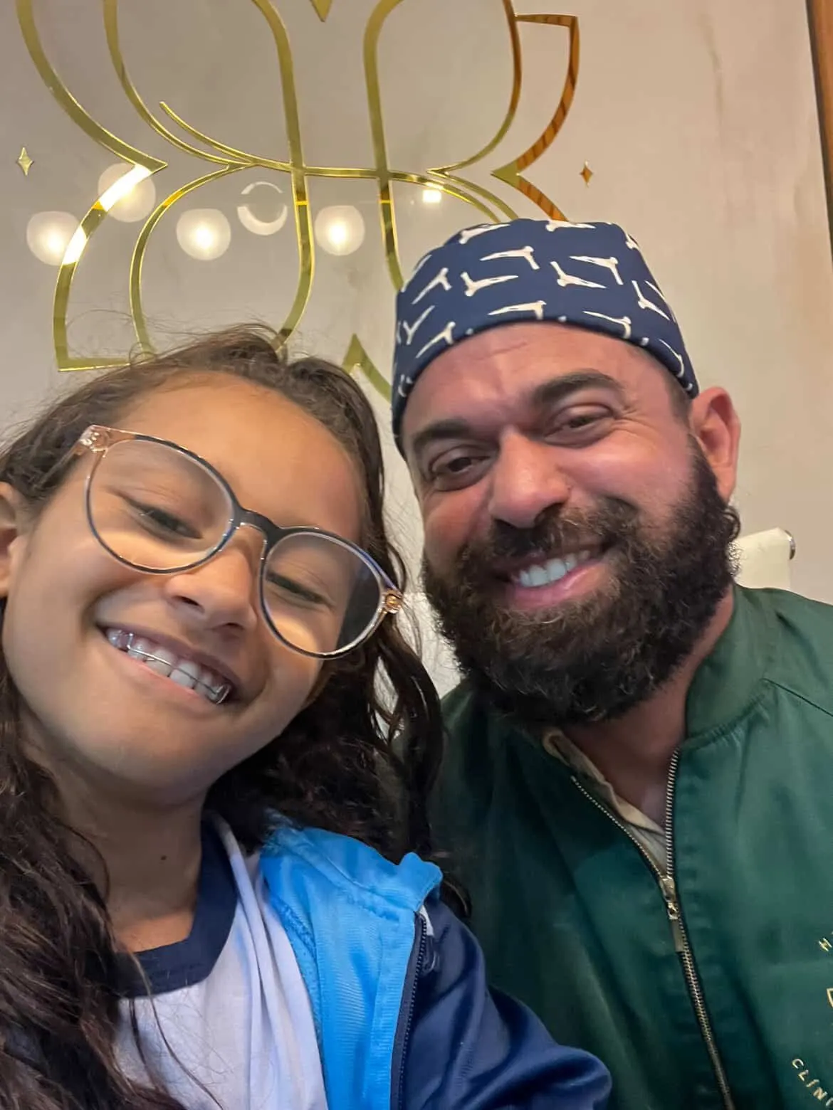 Dentista da Humanized e uma paciente criança sorrindo juntos na recepção da clínica